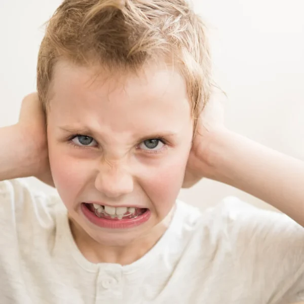 an angry boy covering his ears