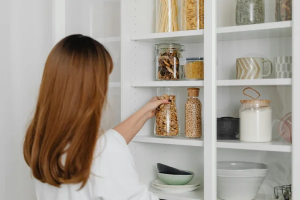 A woman checking items in the pantry.