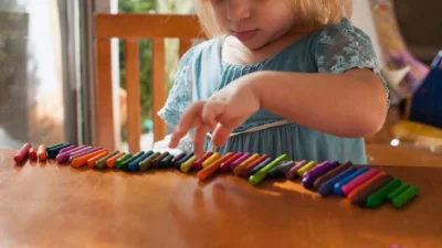 autistic girl lining up crayons