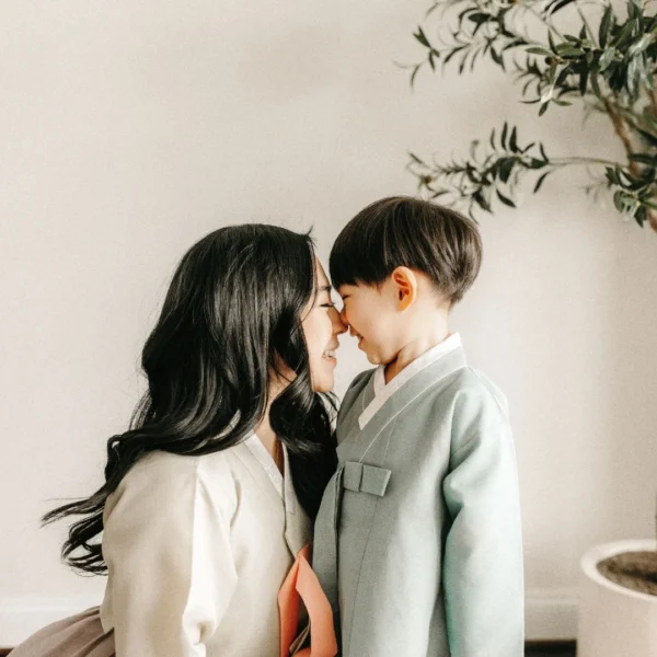 a mother and her young son gently touch noses