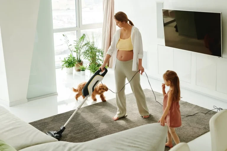 Mother teaching daughter how to clean the living room