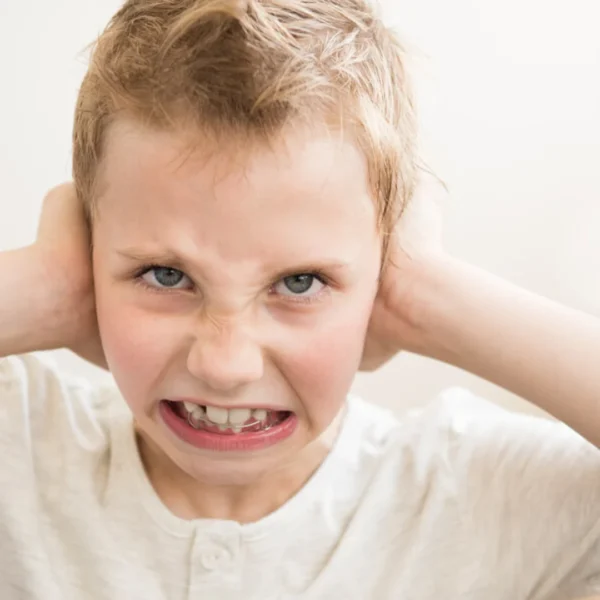 an angry boy covering his ears