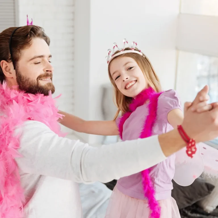 father and daughter in playful costumes dancing together