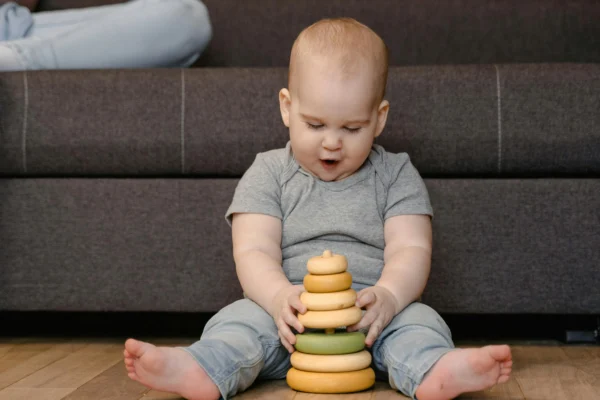 Infant playing with wooden toys