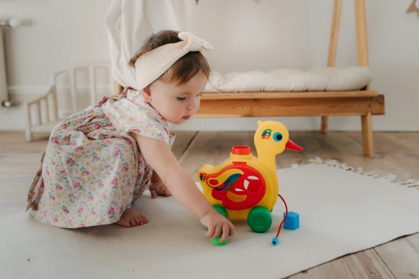 Baby playing with a toy duck
